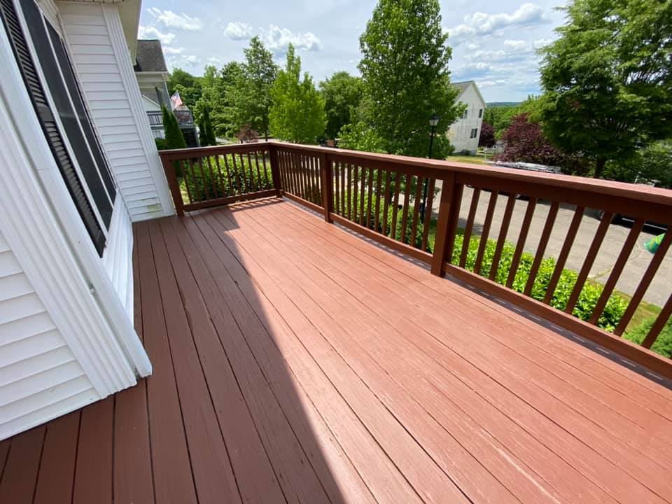 Spacious deck with brown railings overlooking green landscape