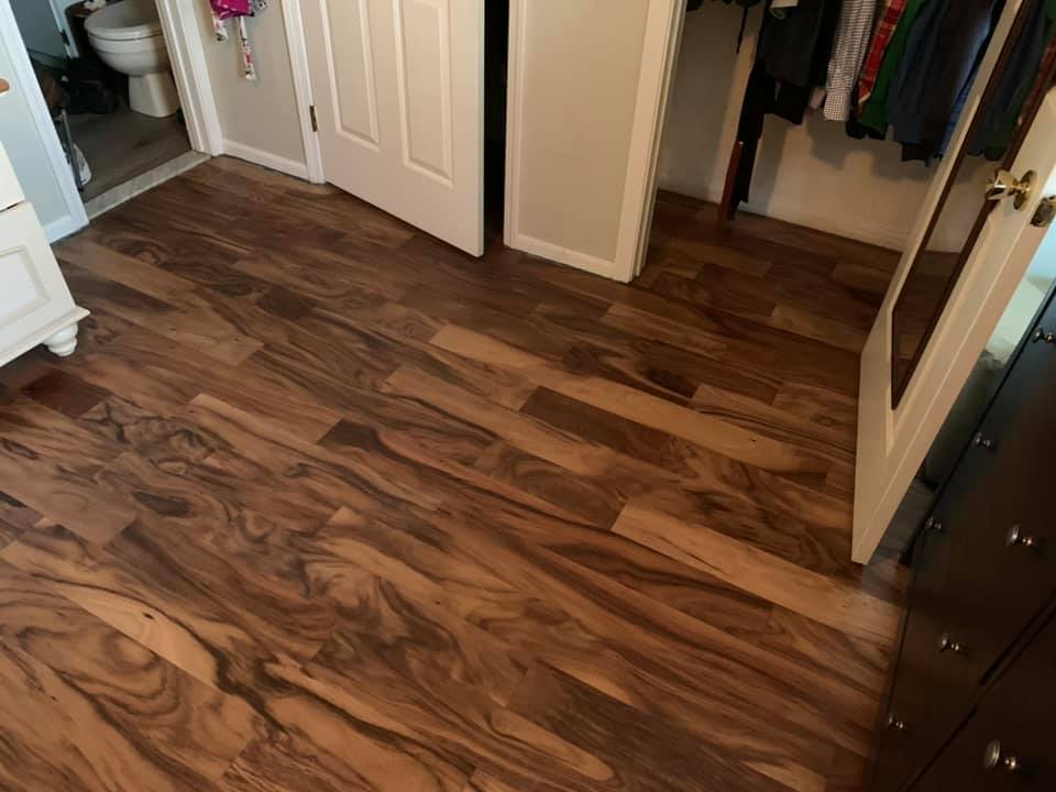 Rich hardwood flooring installation in bedroom and hallway