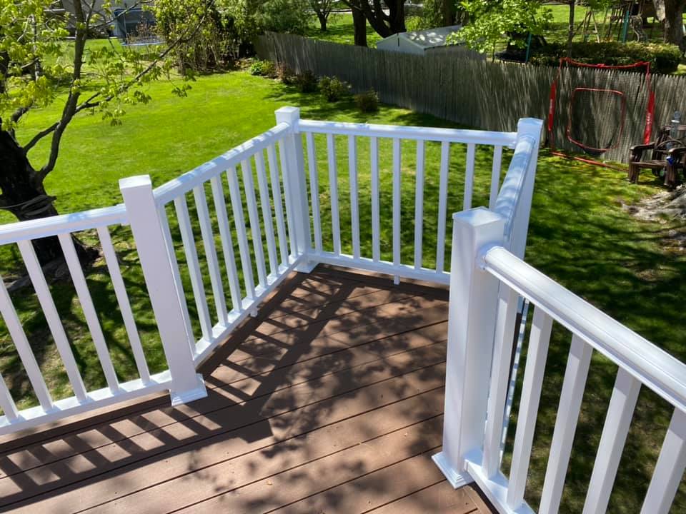 Curved deck design with white railings and brown decking