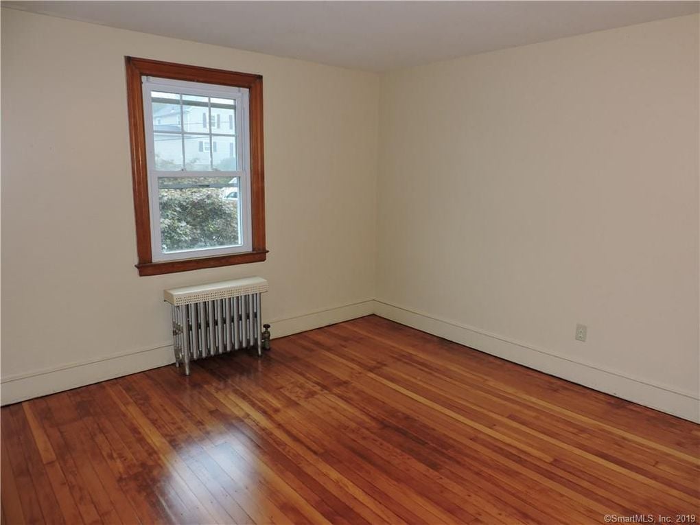 Refinished hardwood floors in bedroom with window