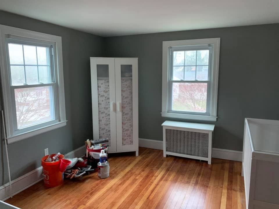 Hardwood flooring installation in room with gray walls