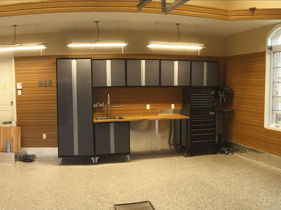 Professional garage with custom cabinetry, LED lighting, and organized workspace