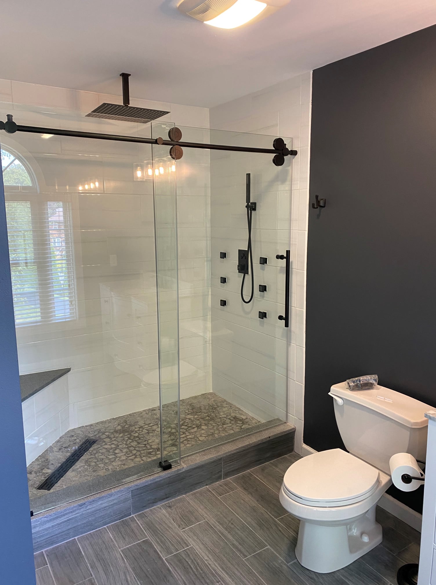 Luxury glass shower with modern fixtures and gray tile flooring