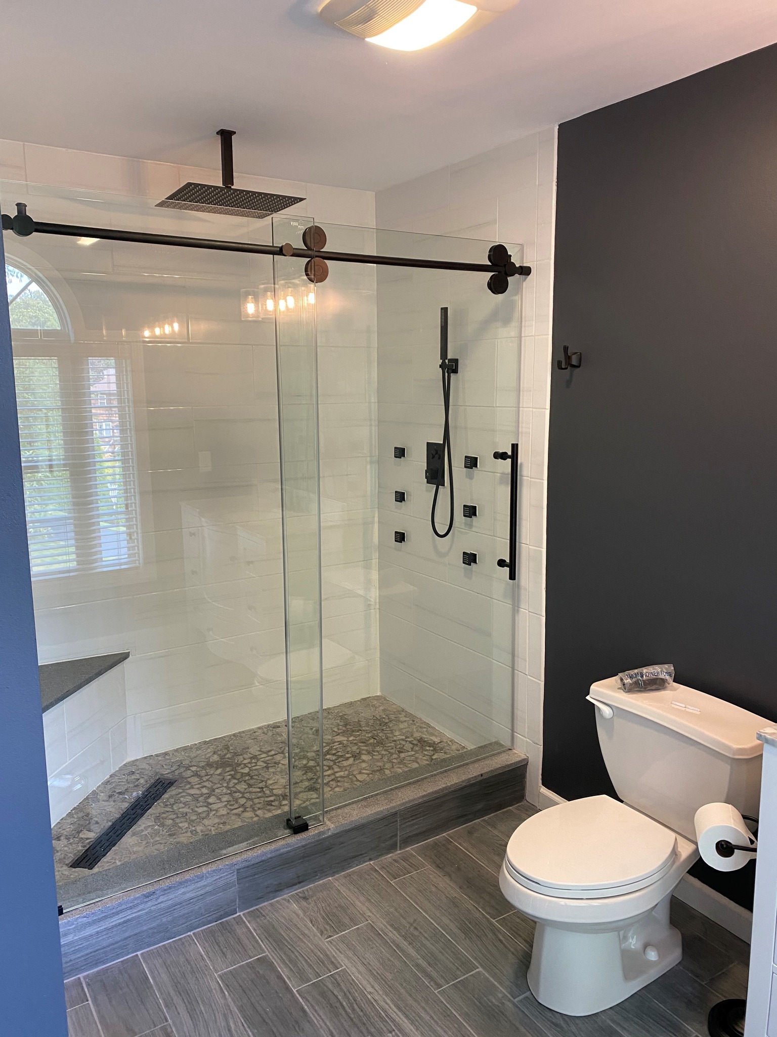 Bathroom remodel with glass shower and modern black fixtures
