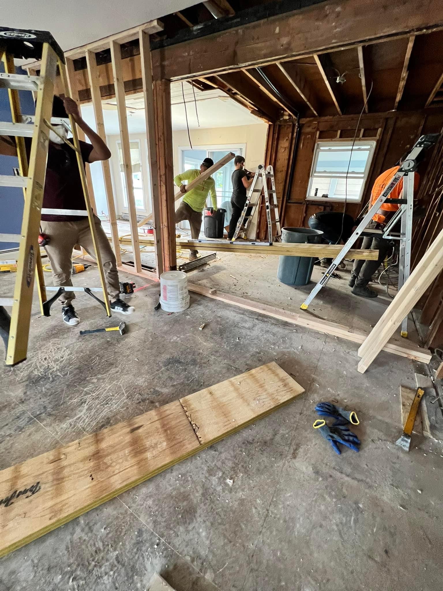 Construction team working on structural renovation with exposed framing