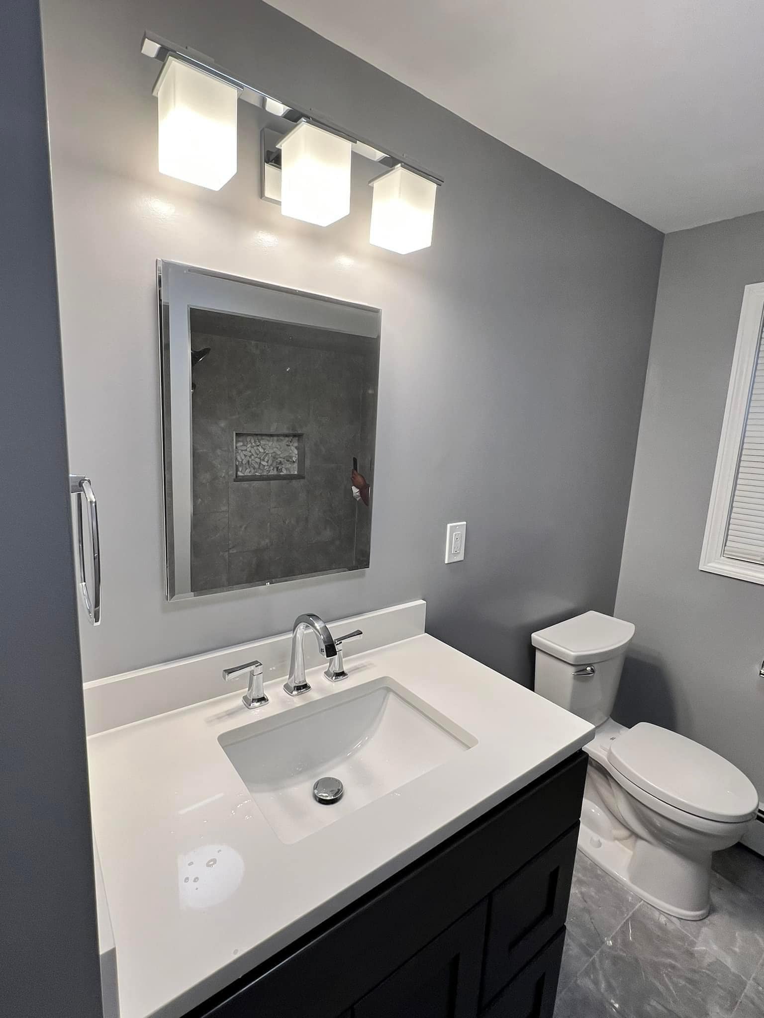 Contemporary bathroom vanity with modern lighting and mirror