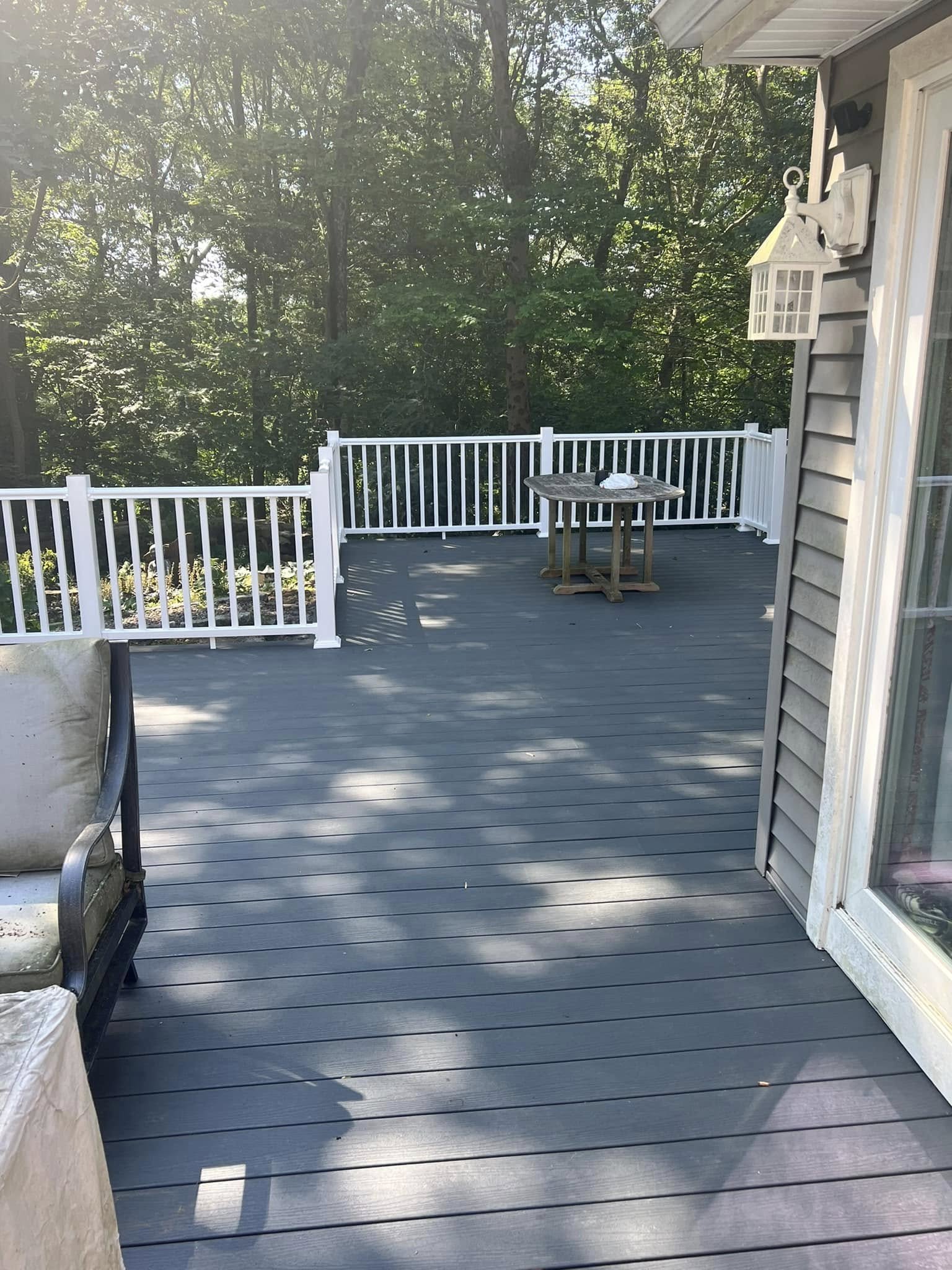 Modern gray deck with white railings and outdoor furniture