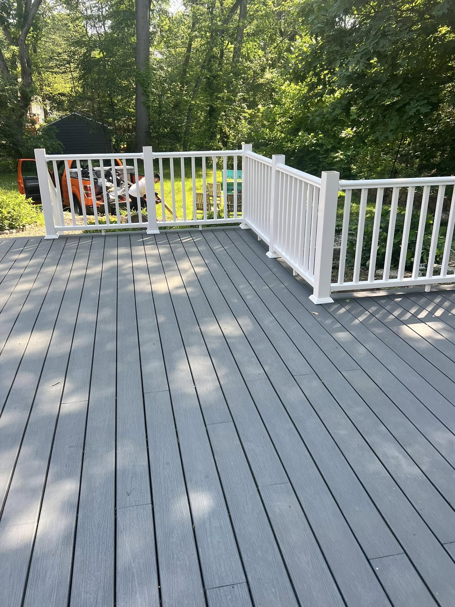 Spacious gray deck with white railings and gate access