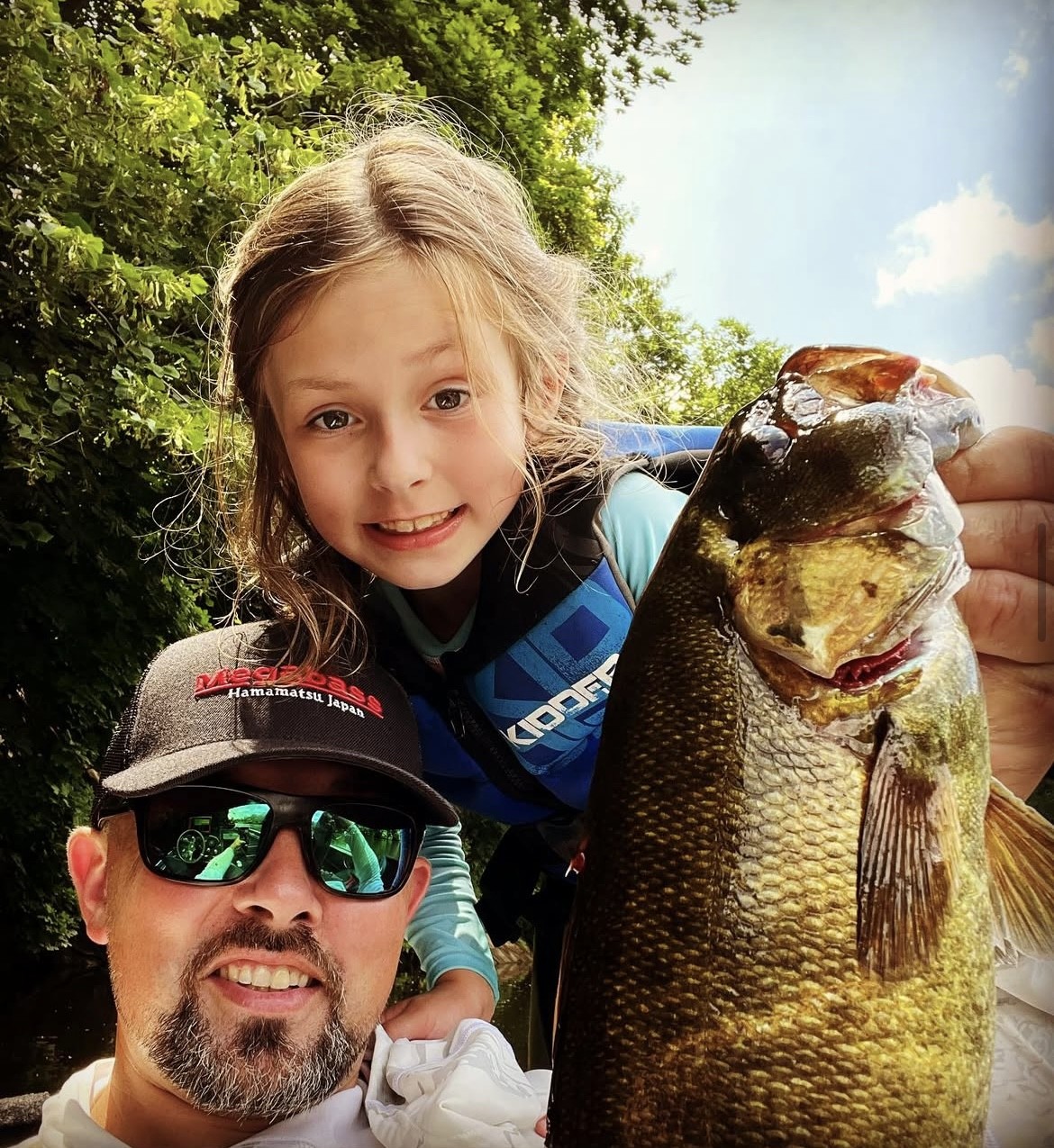 Rob with his daughter Mackenzie holding a large bass fish
