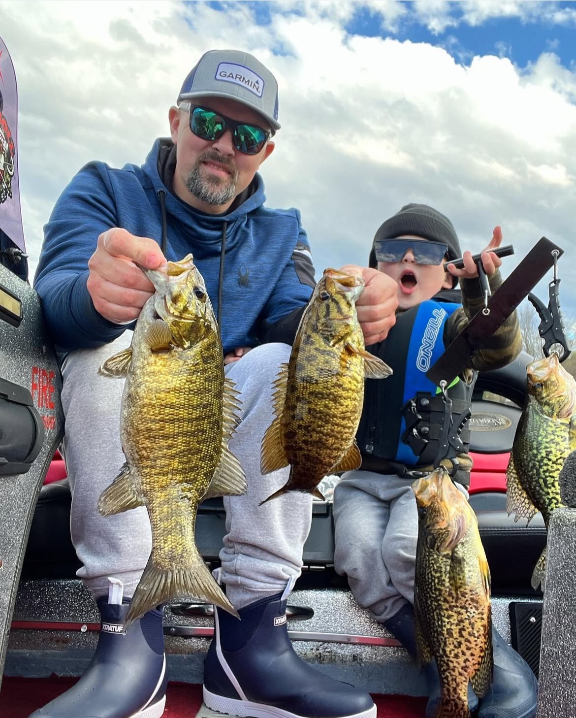 Rob fishing with his son Luke, both holding bass fish