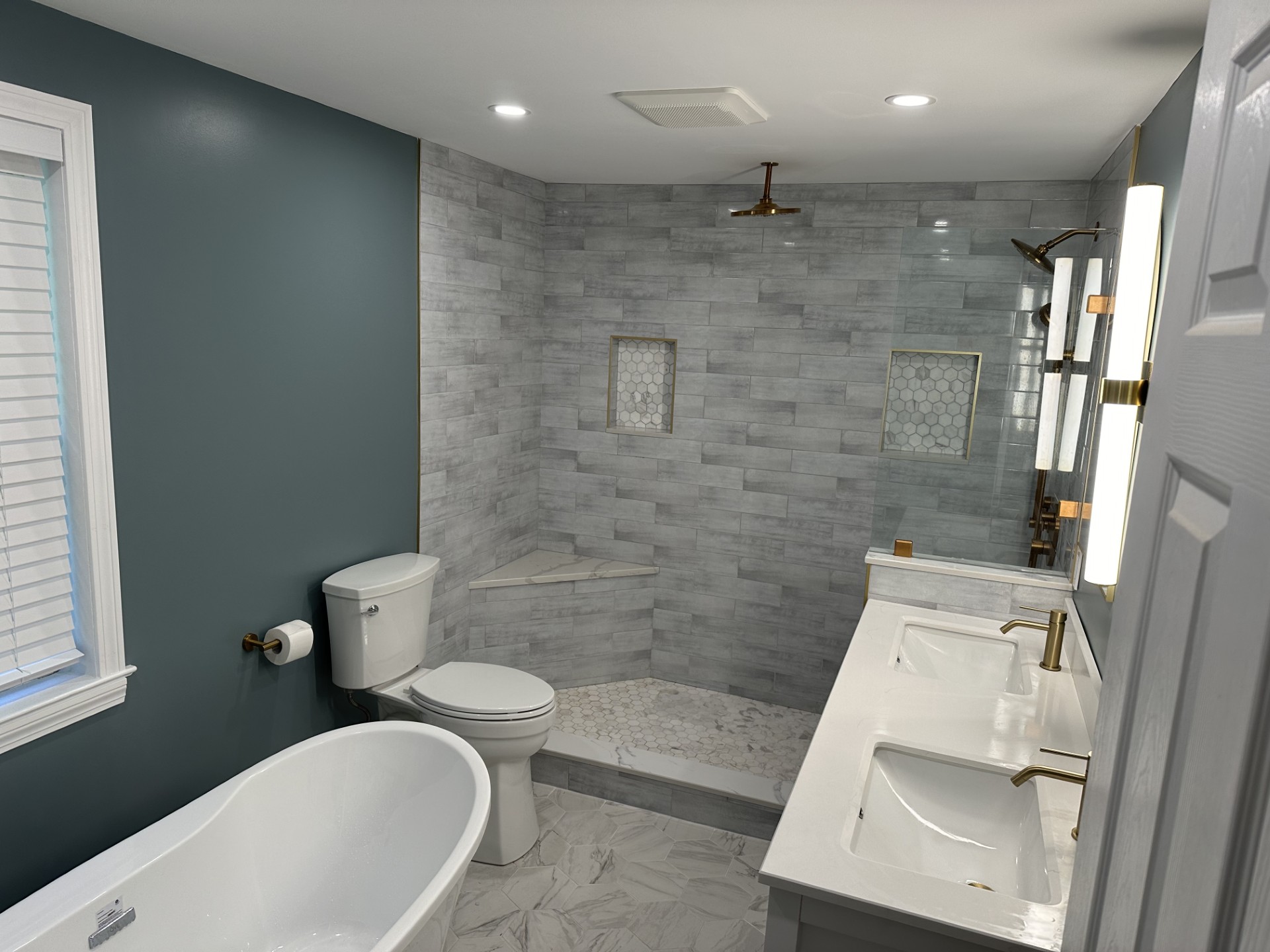 Contemporary bathroom with walk-in shower, marble subway tile, and built-in niches